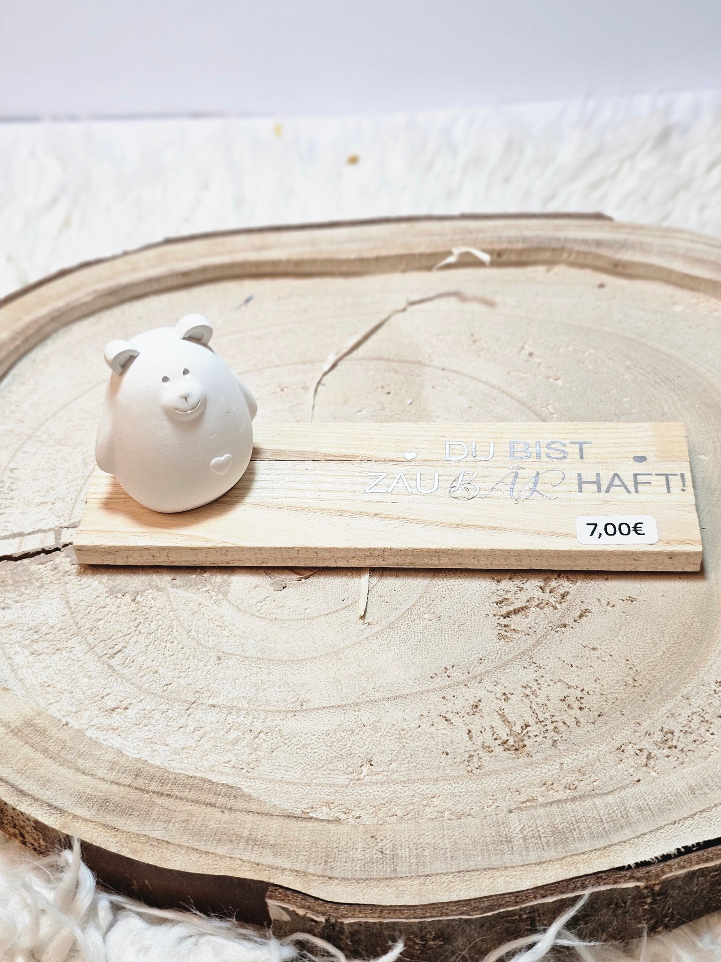 Kleines Bärchen auf Holzbrettchen